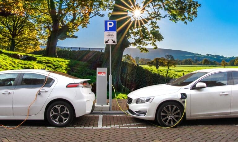 Two electric cars charging at a station, showcasing eco-friendly transportation options